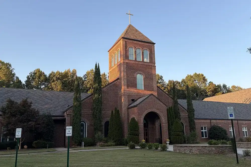 Brick bell tower and arched entrance of All Saints Catholic Church in Lake Wylie, South Carolina